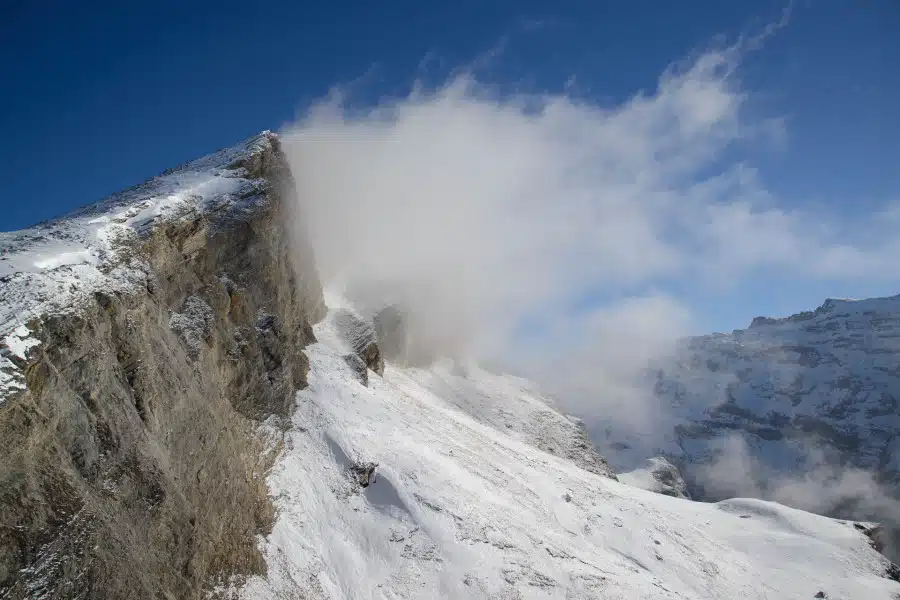 Verschneite Berglandschaft mit Wolkenverhangenen Gipfeln im Wallis, Schweiz