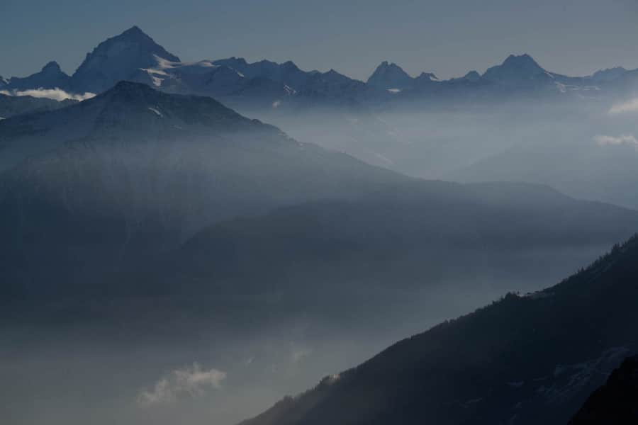 Nebelige Berglandschaft mit schneebedeckten Gipfeln in den Walliser Alpen.