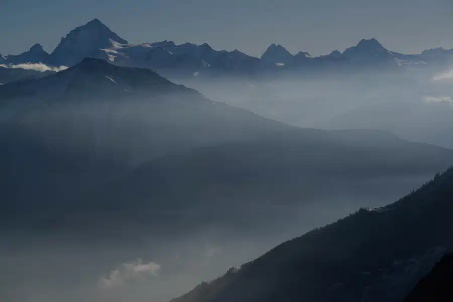 Nebelige Berglandschaft mit schneebedeckten Gipfeln in den Walliser Alpen.