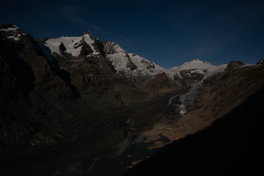 Großglockner bei Nacht im Mondlicht mit Gletschern und Sternenhimmel.