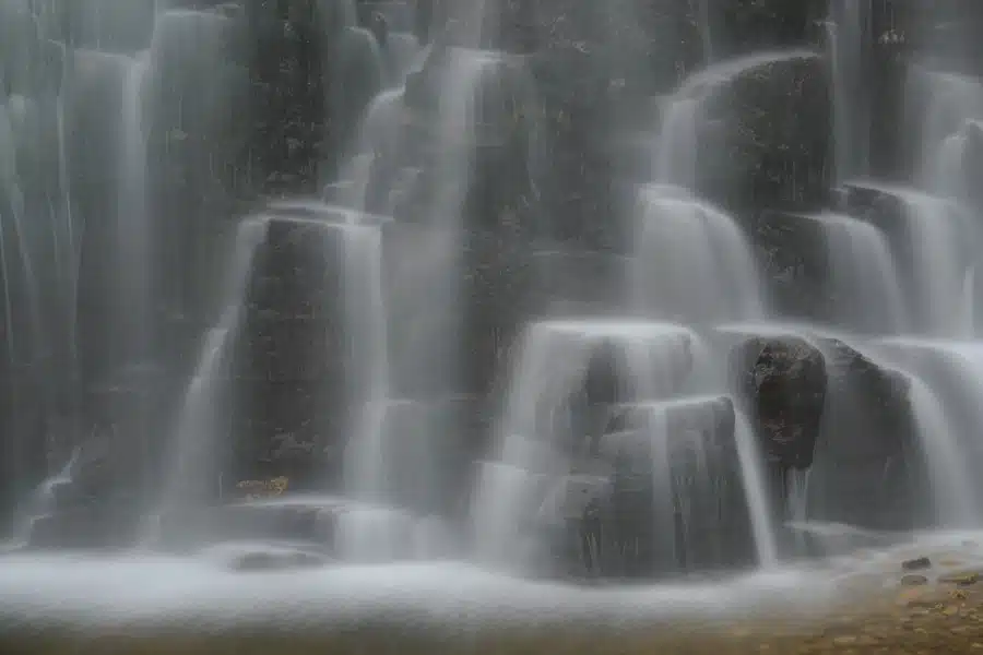 Mehrstufiger Wasserfall fließt über Felsen in Norwegen.