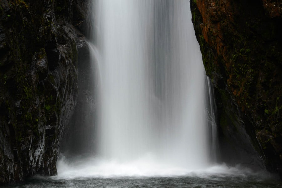 Ein kraftvoller Wasserfall stürzt zwischen schroffen norwegischen Felsen herab.