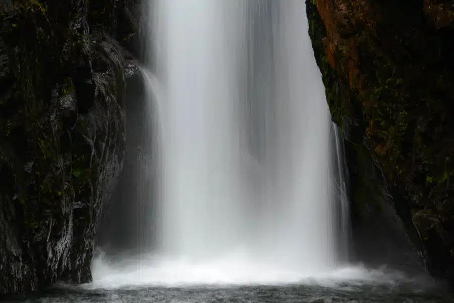 Ein kraftvoller Wasserfall stürzt zwischen schroffen norwegischen Felsen herab.