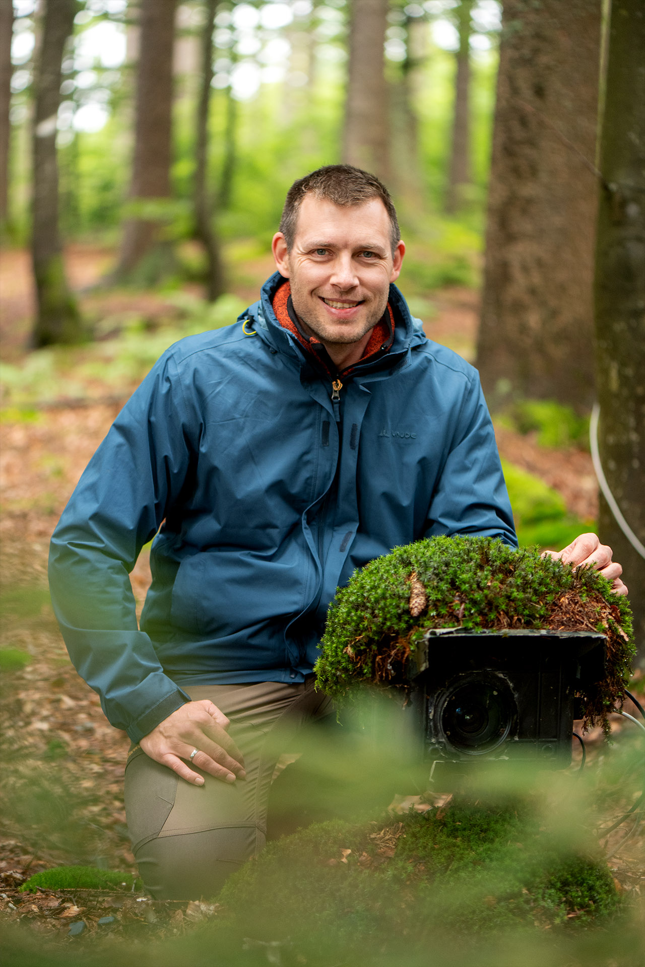 Der Naturfotograf Julius Kramer installiert eine Kamerafalle an einem Felsen.
