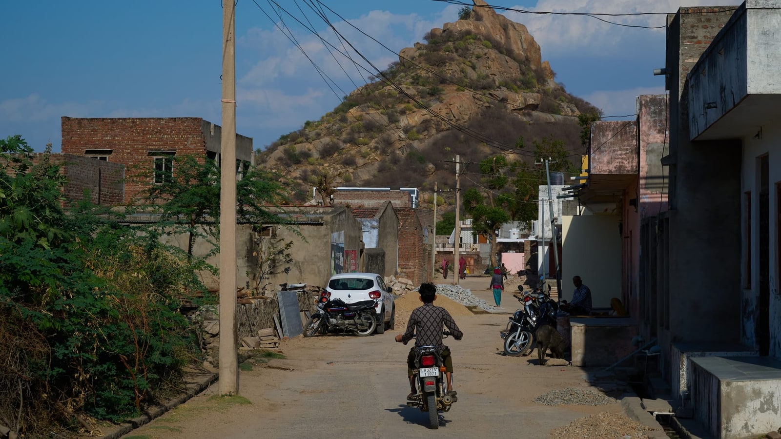 Dorfstraße in Bera, im Hintergrund eine Granitkuppe